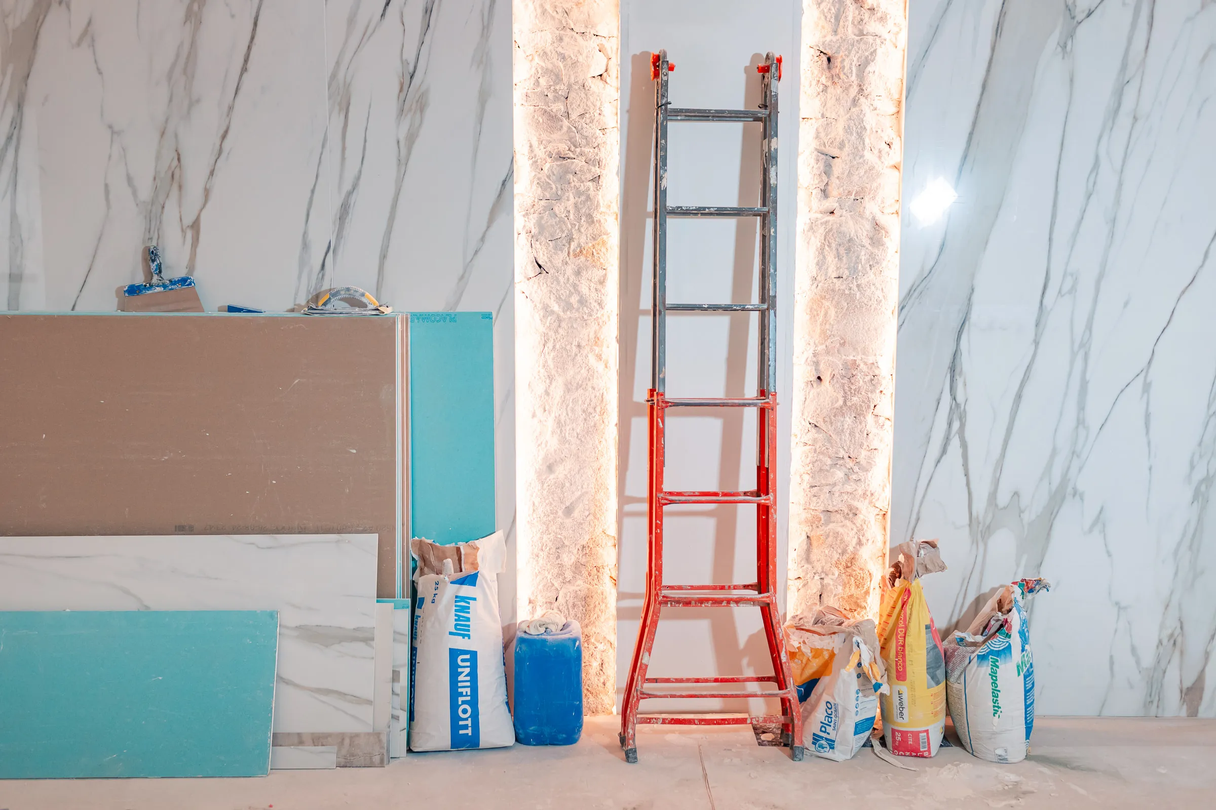 Construction materials laid out against the marble back of the shelving